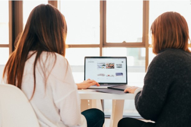 Two professionals sharing laptop to implement PSA after learning what is professional services automation